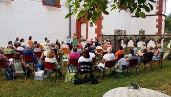 %0 Zuhörerinnen und Zuhörer haben sich an der St. Lambertus Kirche in Thulba um Titus Müller versammelt.
