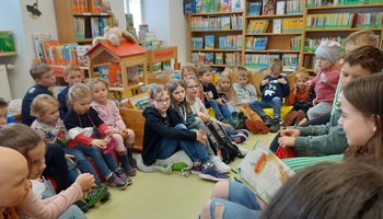 Kinder lauschen in der Bücherei dem Vorlesen.