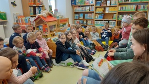 Kinder lauschen in der Bücherei dem Vorlesen.