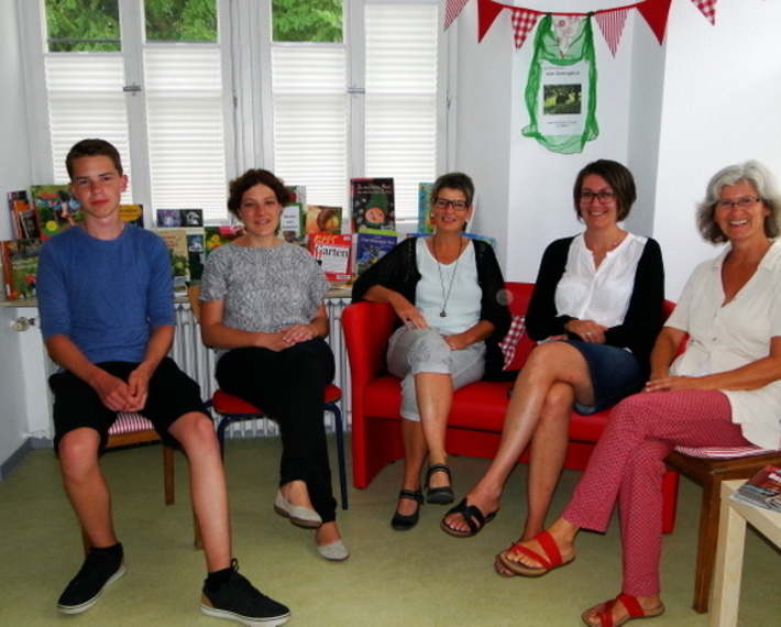 Vier Mitarbeiterinnen und ein Mitarbeiter im Bereich der Ausleihe.